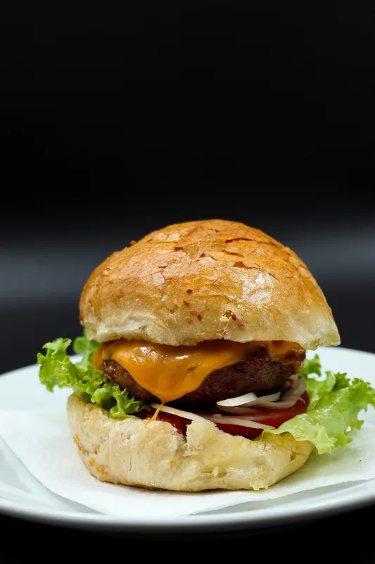 Koyu masada burger, yanında patates ve sos