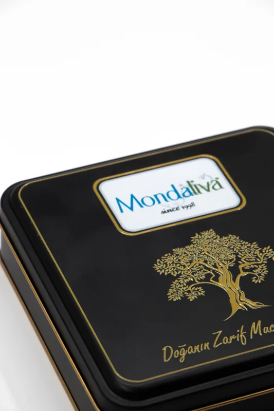 Beyaz fon önünde Mondaliva siyah metal kutu, kapağında logo